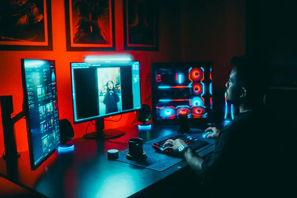 Graduate working at a multi-monitor game development setup