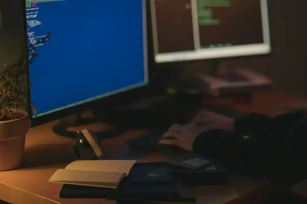 A student coding in a game engine with dual monitors